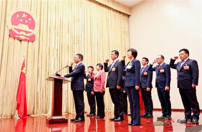 赵立香,王海峰等宣誓人面向国徽,右手举拳,高声诵读誓词:"我宣誓:忠于